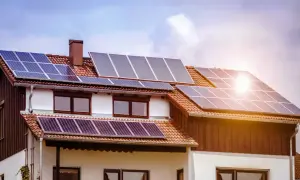 Casa con paneles solares fotovoltaicos en el tejado, captando la luz del sol para generar energía limpia.