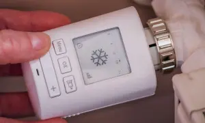 Termostato digital para radiador, mostrando un copo de nieve. Controla los tipos de calefacción para una casa de forma inteligente.