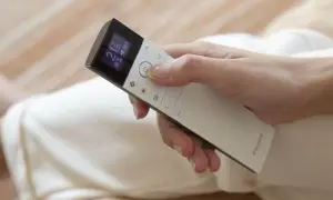 Mano ajustando el control remoto de un cool aire acondicionado a 21 grados.