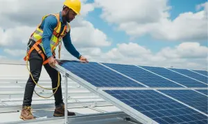 Técnico instala paneles solares, parte esencial de la memoria técnica de una instalación fotovoltaica.