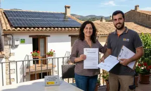 Mujer y hombre sonríen con documentos de legalización de placas solares. La instalación de autoconsumo está legalizada.
