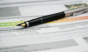 Pluma sobre documento con datos de certificado eficiencia energética Euskadi. Muestra consumo y requisitos.