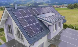 Tejado de casa de campo con paneles solares y vistas a montañas verdes.