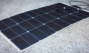 Panel solar negro sobre fondo de hormigón. Los paneles solares sirven para generar energía limpia y renovable, aprovechando la luz del sol.