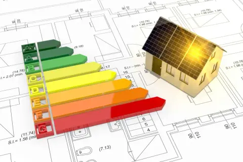 Casa con paneles solares sobre planos. Escala de eficiencia energética de A++ a G. Se puede firmar sin certificado energético.
