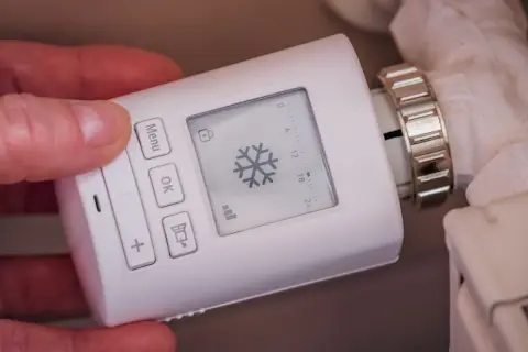 Termostato digital para radiador, mostrando un copo de nieve. Controla los tipos de calefacción para una casa de forma inteligente.