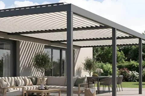 Moderna pérgola fotovoltaica en una terraza con sofá y mesa. Sombra y energía solar para tu espacio exterior.
