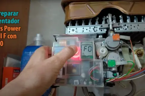 Mano presionando botón para resetear caldera Junkers Power Control F con error F0.