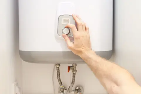 Ajustando el dial para alcanzar la temperatura ideal del termo eléctrico.