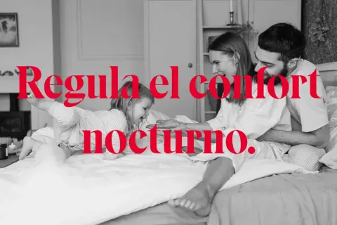 Familia feliz en la cama, disfrutando de la temperatura ideal para dormir. El confort nocturno es clave.