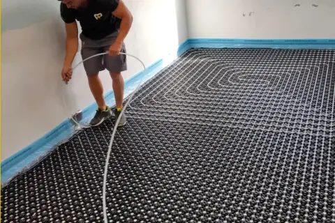 Instalador coloca tuberías para suelo radiante. Un sistema eficiente para calentar tu hogar, con posibles subvenciones suelo radiante.
