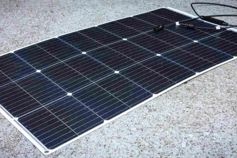 Panel solar negro sobre fondo de hormigón. Los paneles solares sirven para generar energía limpia y renovable, aprovechando la luz del sol.