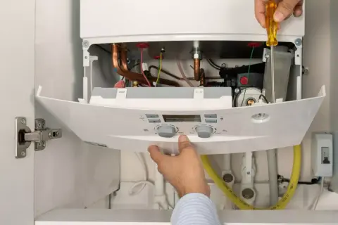 Instalador ajusta caldera de gas natural. Aprovecha el plan renove calderas gas natural Castilla y León para modernizar tu hogar.