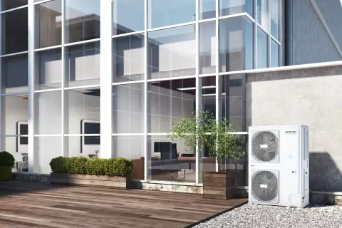Unidad exterior de aire acondicionado Kosner, ideal para un rendimiento estacional óptimo en edificios modernos con grandes ventanales.