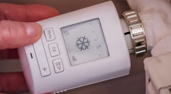 Termostato digital para radiador, mostrando un copo de nieve. Controla los tipos de calefacción para una casa de forma inteligente.