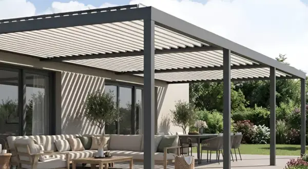 Moderna pérgola fotovoltaica en una terraza con sofá y mesa. Sombra y energía solar para tu espacio exterior.