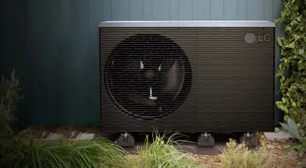 Unidad exterior de bomba de calor LG, una de las alternativas a la aerotermia, instalada en un jardín.