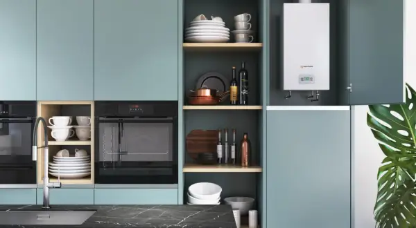 Calentador de agua a gas, ideal para butano o gas natural, instalado en una cocina moderna con armarios turquesa y electrodomésticos integrados.