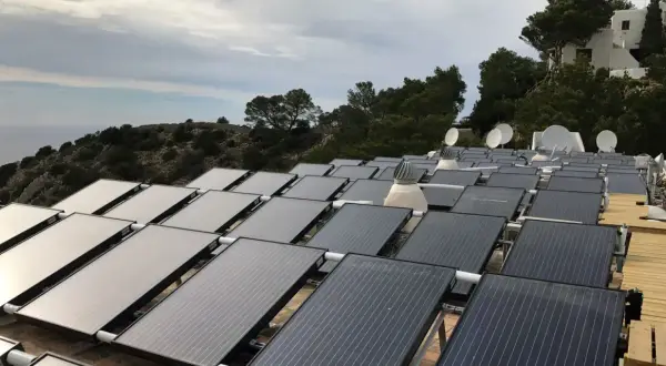 Gran instalación de placas solares híbridas en una ladera con vistas al mar.