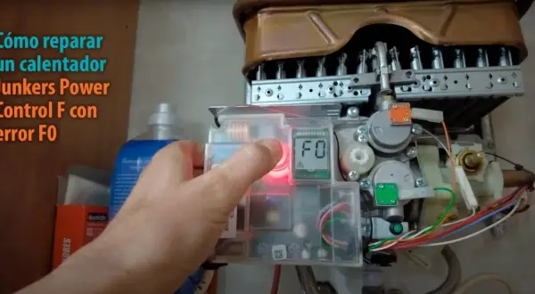 Mano presionando botón para resetear caldera Junkers Power Control F con error F0.