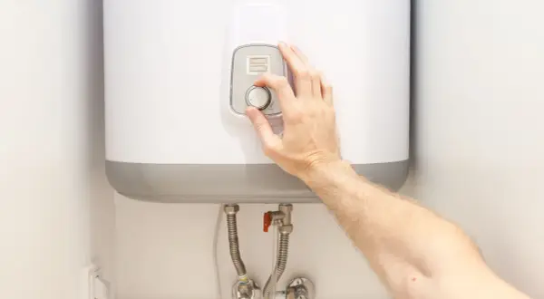 Ajustando el dial para alcanzar la temperatura ideal del termo eléctrico.