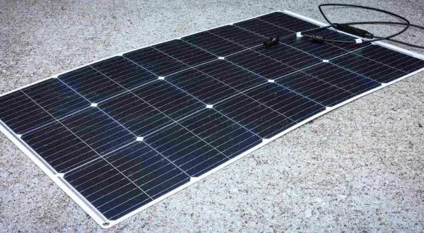 Panel solar negro sobre fondo de hormigón. Los paneles solares sirven para generar energía limpia y renovable, aprovechando la luz del sol.