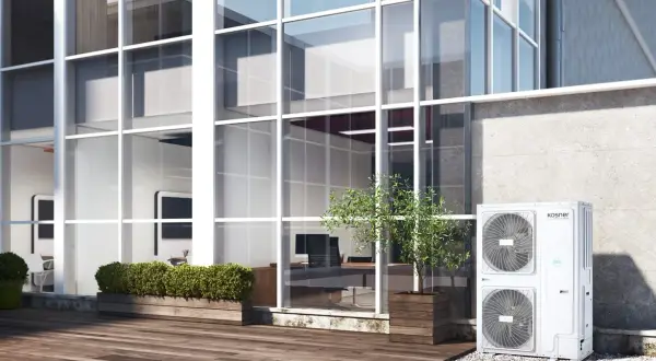 Unidad exterior de aire acondicionado Kosner, ideal para un rendimiento estacional óptimo en edificios modernos con grandes ventanales.