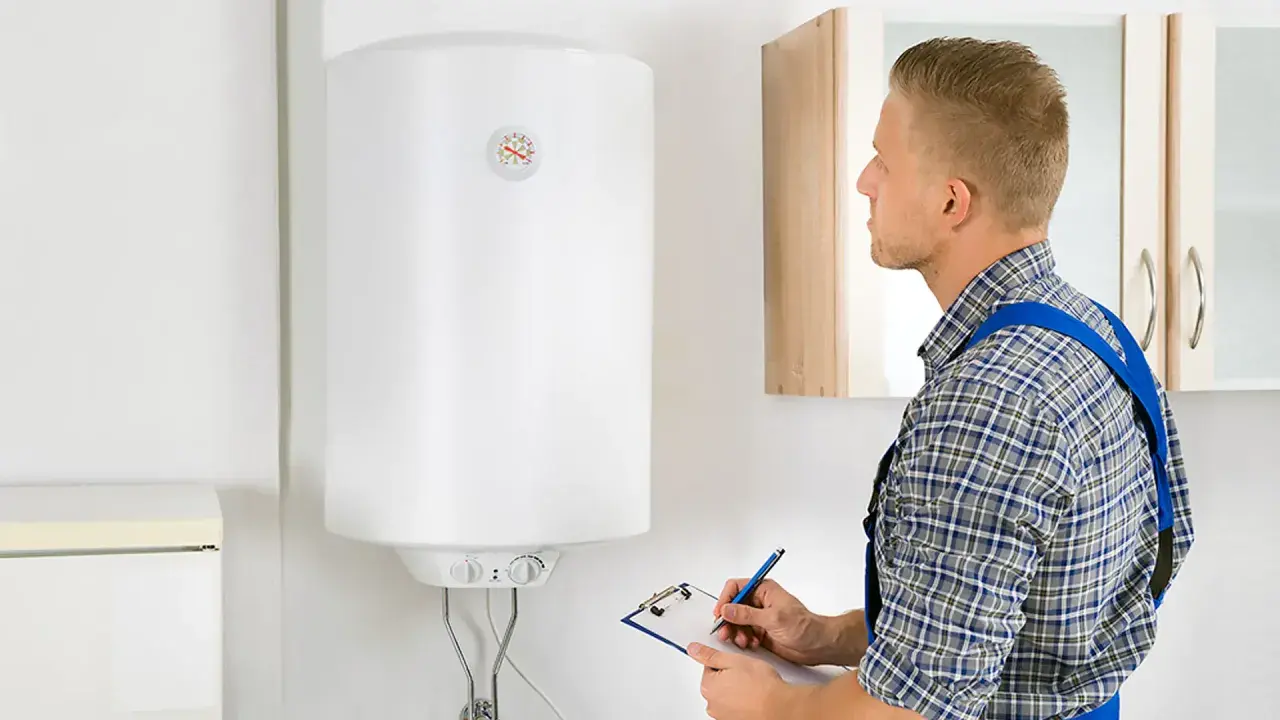 Técnico revisa un termo eléctrico blanco, anotando en una libreta.