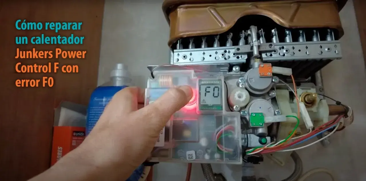 Mano presionando botón para resetear caldera Junkers Power Control F con error F0.