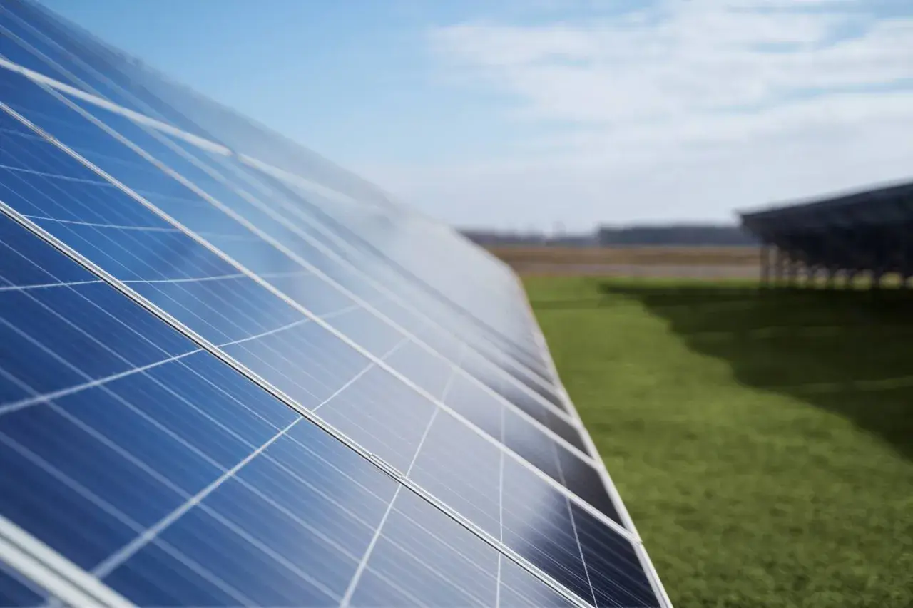Paneles solares en un campo verde. ¿Cuántos kWh produce un panel solar de 450W? La energía solar es el futuro.