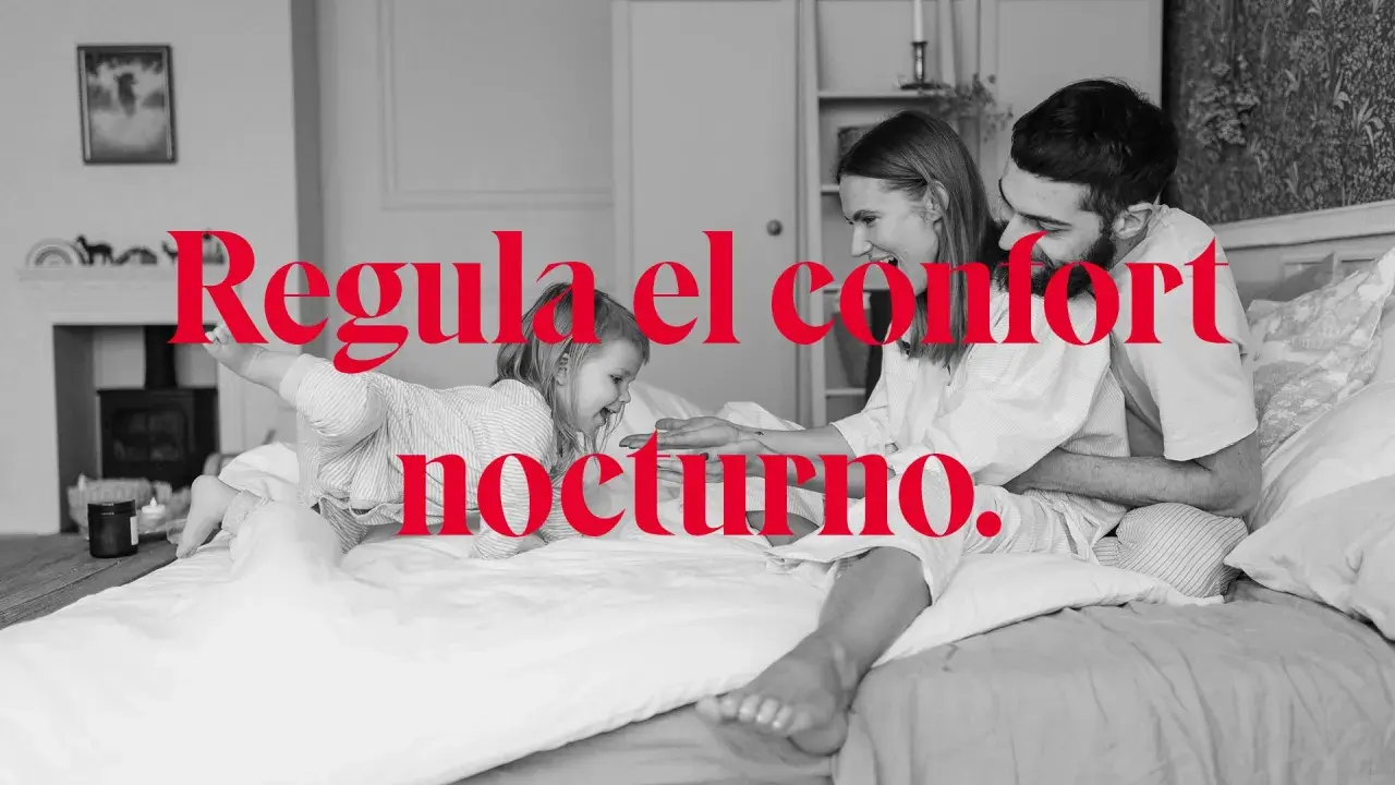 Familia feliz en la cama, disfrutando de la temperatura ideal para dormir. El confort nocturno es clave.