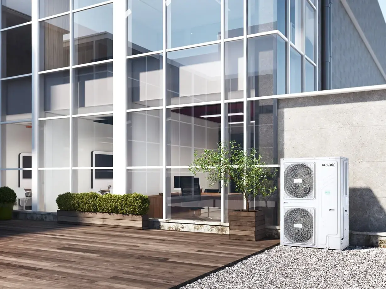 Unidad exterior de aire acondicionado Kosner, ideal para un rendimiento estacional óptimo en edificios modernos con grandes ventanales.