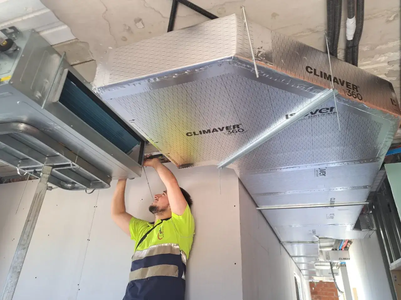 Un t&eacute;cnico instala un sistema de climatizaci&oacute;n, demostrando que es dif&iacute;cil instalar un aire acondicionado.