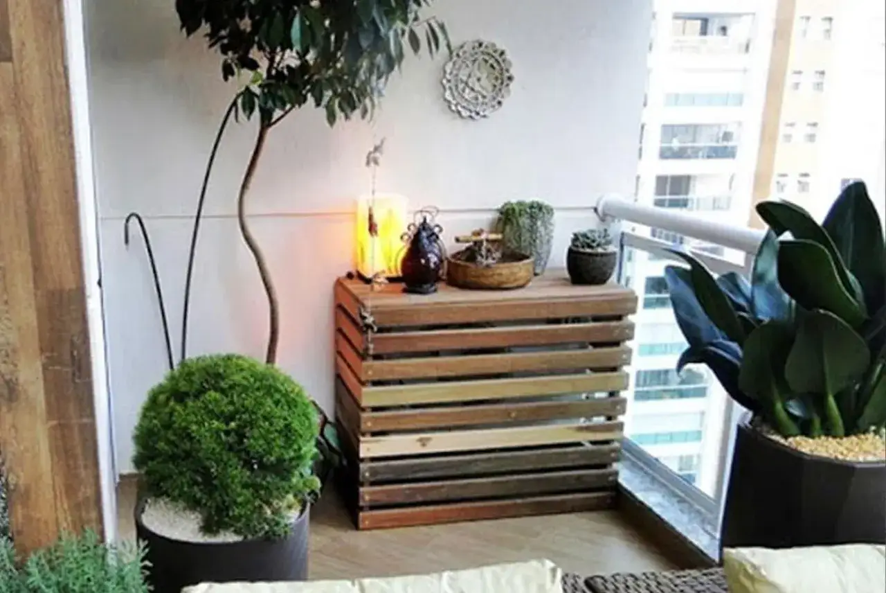Caja de madera con listones, ideal como ideas para tapar tubos de aire acondicionado en balcones. Decora con plantas y luces.