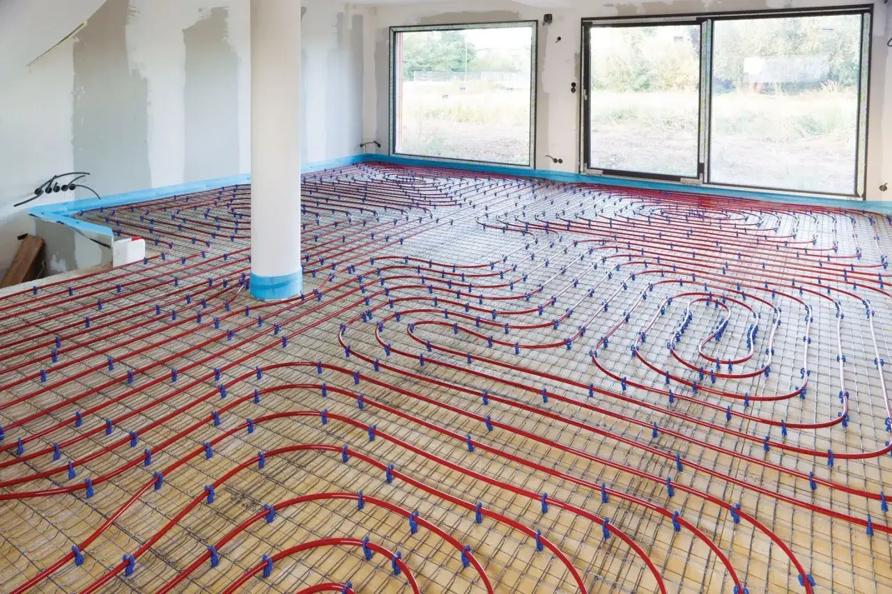 Instalación de suelo radiante, el mejor sistema climatización vivienda unifamiliar. Tuberías rojas sobre malla metálica, preparadas para hormigonar.