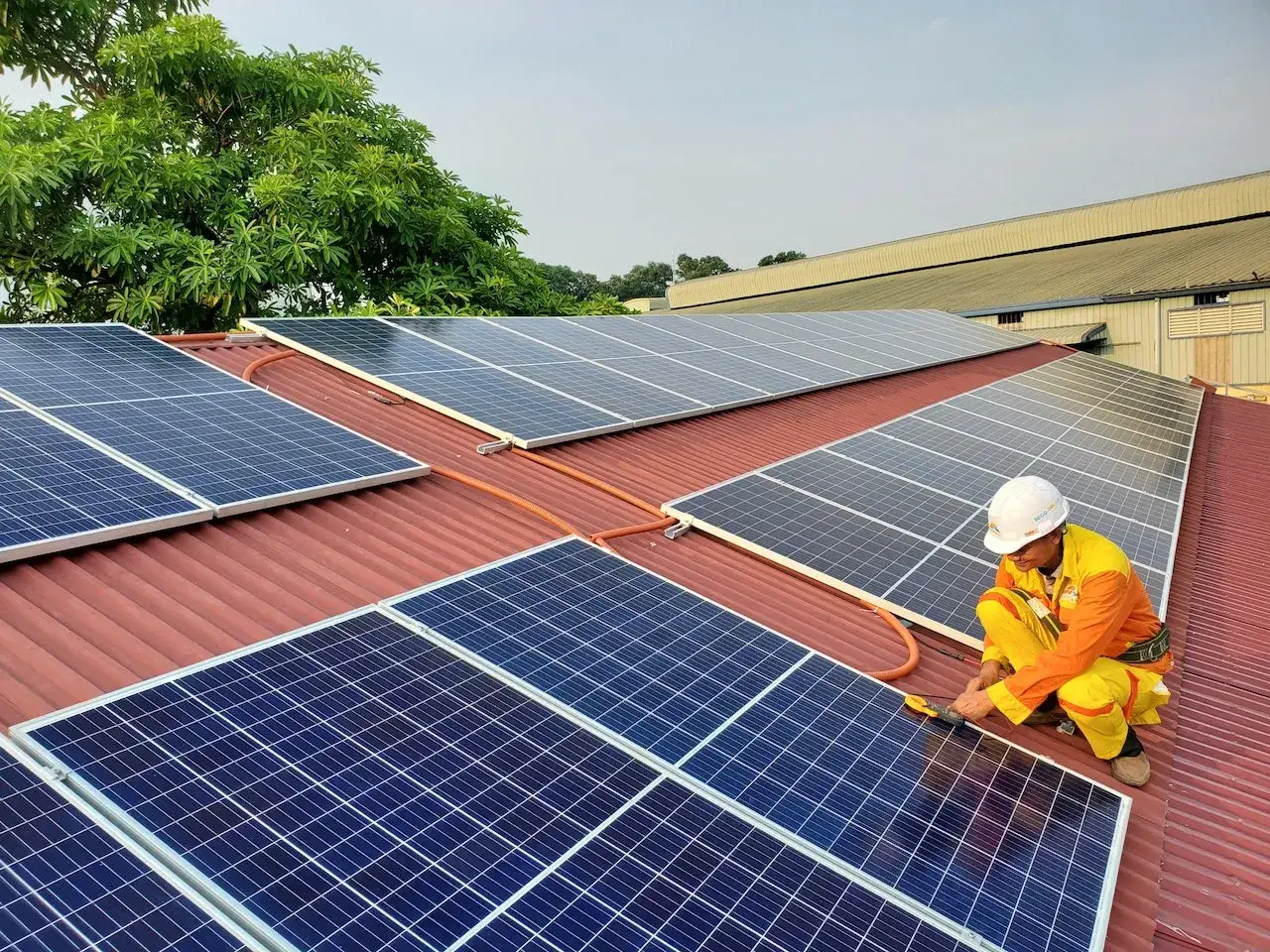 Instalador trabajando en un tejado con paneles solares. ¿Cuántas placas solares necesito para 5000w?