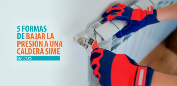 Manos enguantadas ajustan una llave inglesa a un radiador, mostrando cómo quitar presión a la caldera.