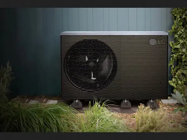 Unidad exterior de bomba de calor LG, una de las alternativas a la aerotermia, instalada en un jardín.