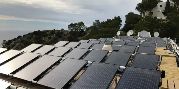 Gran instalación de placas solares híbridas en una ladera con vistas al mar.