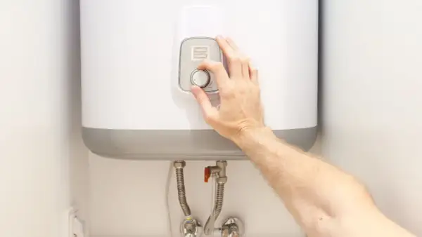 Ajustando el dial para alcanzar la temperatura ideal del termo eléctrico.