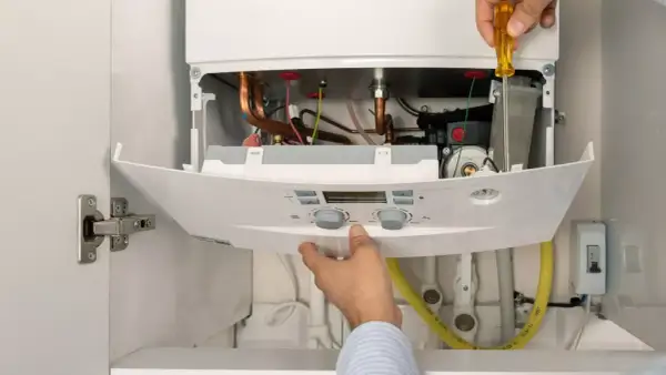Instalador ajusta caldera de gas natural. Aprovecha el plan renove calderas gas natural Castilla y León para modernizar tu hogar.